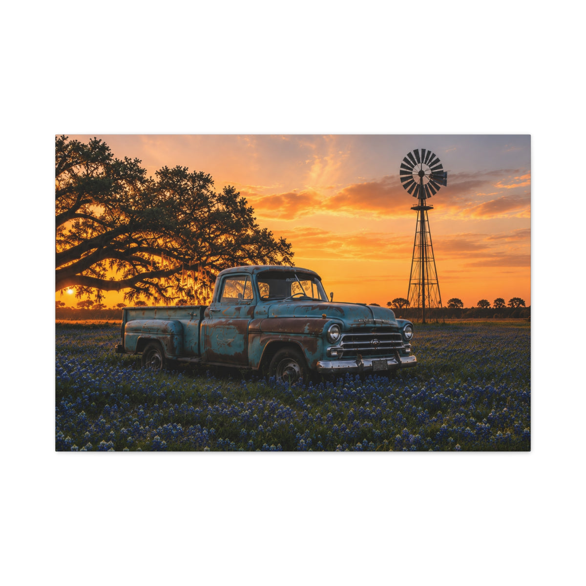 A rectangular The Windmill canvas print showing a weathered blue vintage pickup in a field of bluebonnets at sunset, with a windmill and large oak tree in the background, photographed at an angle on a white background.