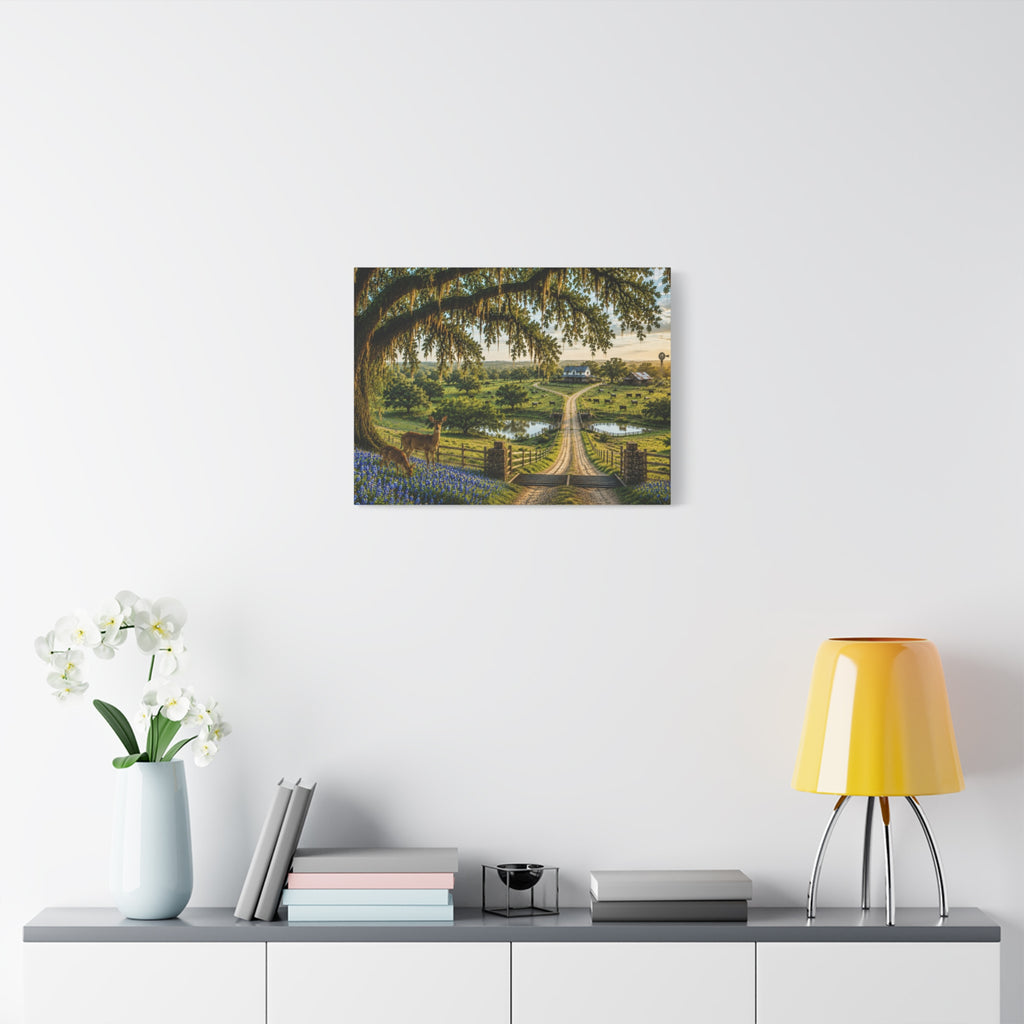 A framed landscape art print depicting a scenic garden path under a large tree, displayed on a white wall above a console table with a yellow lamp, books, and a vase of white flowers.