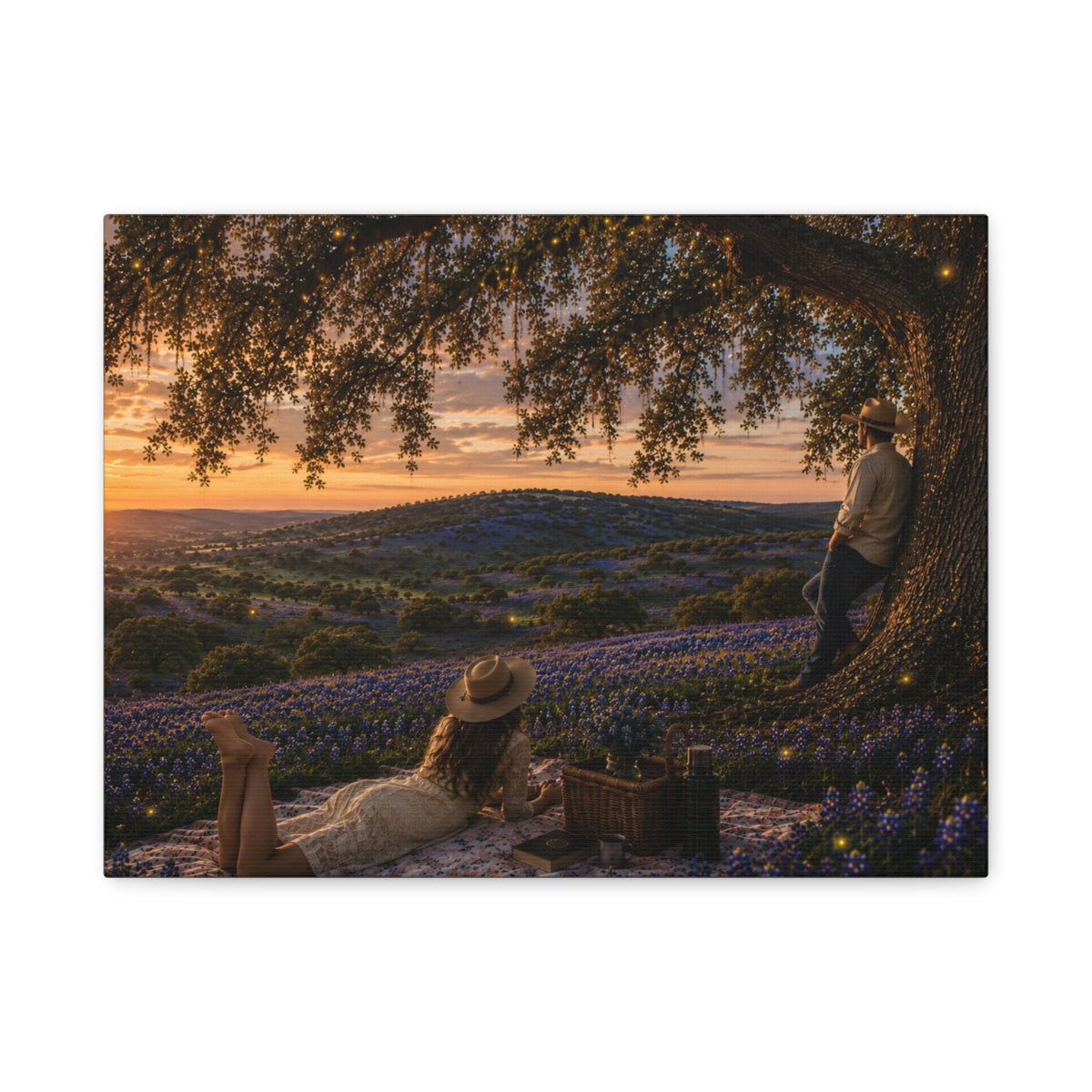 A rectangular wall art print or canvas showing a romantic outdoor picnic scene under a large tree at sunset, with bluebonnet flowers in the foreground and two people visible in the artwork. The print is photographed against a plain white background.