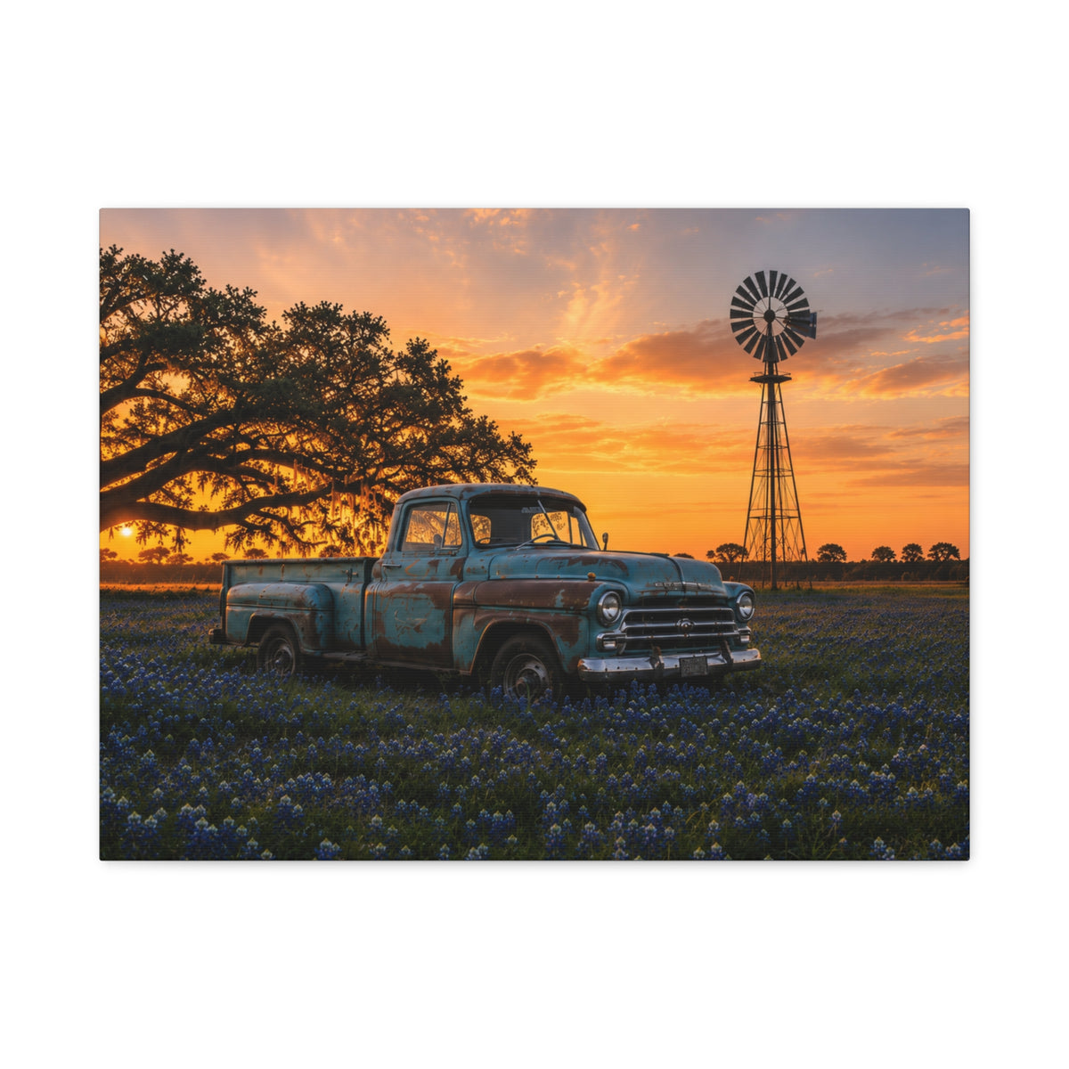 A rectangular The Windmill canvas print showing a weathered blue vintage pickup in a field of bluebonnets at sunset, with a windmill and large oak tree in the background, photographed on a white background.
