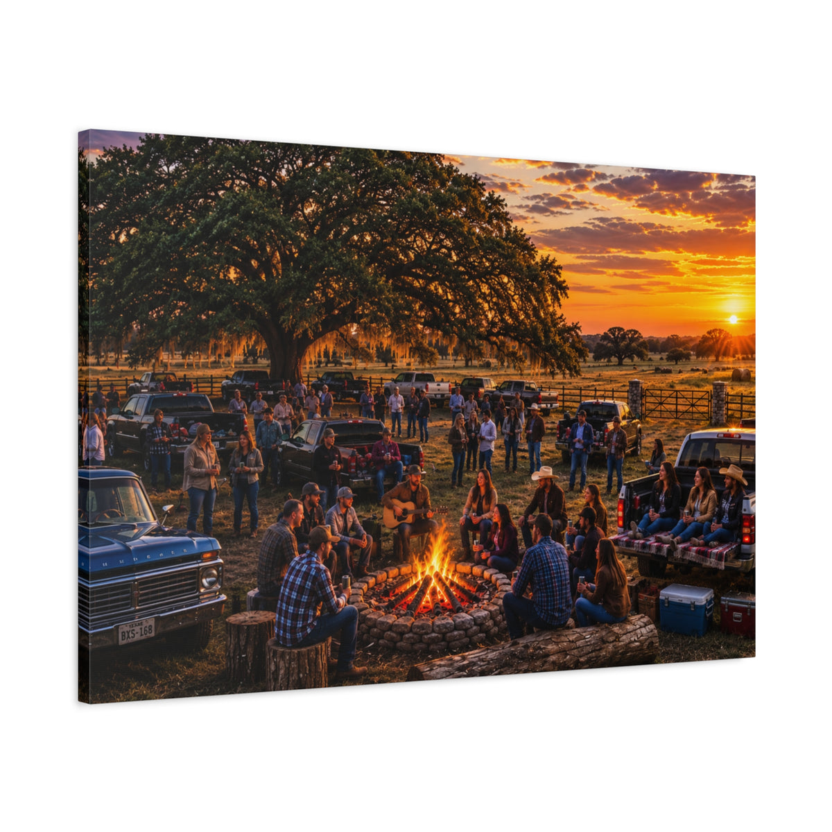 A square Campfire Stories canvas print showing people gathered around a ranch campfire beneath a large oak at sunset, displayed on a white wall above a console with a yellow lamp, books, and white flowers.
