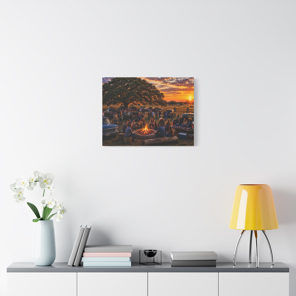A square Campfire Stories canvas print showing friends gathered around a ranch campfire beneath a large oak at sunset, displayed on a dark gray wall above a wooden console with a plant and hanging light.